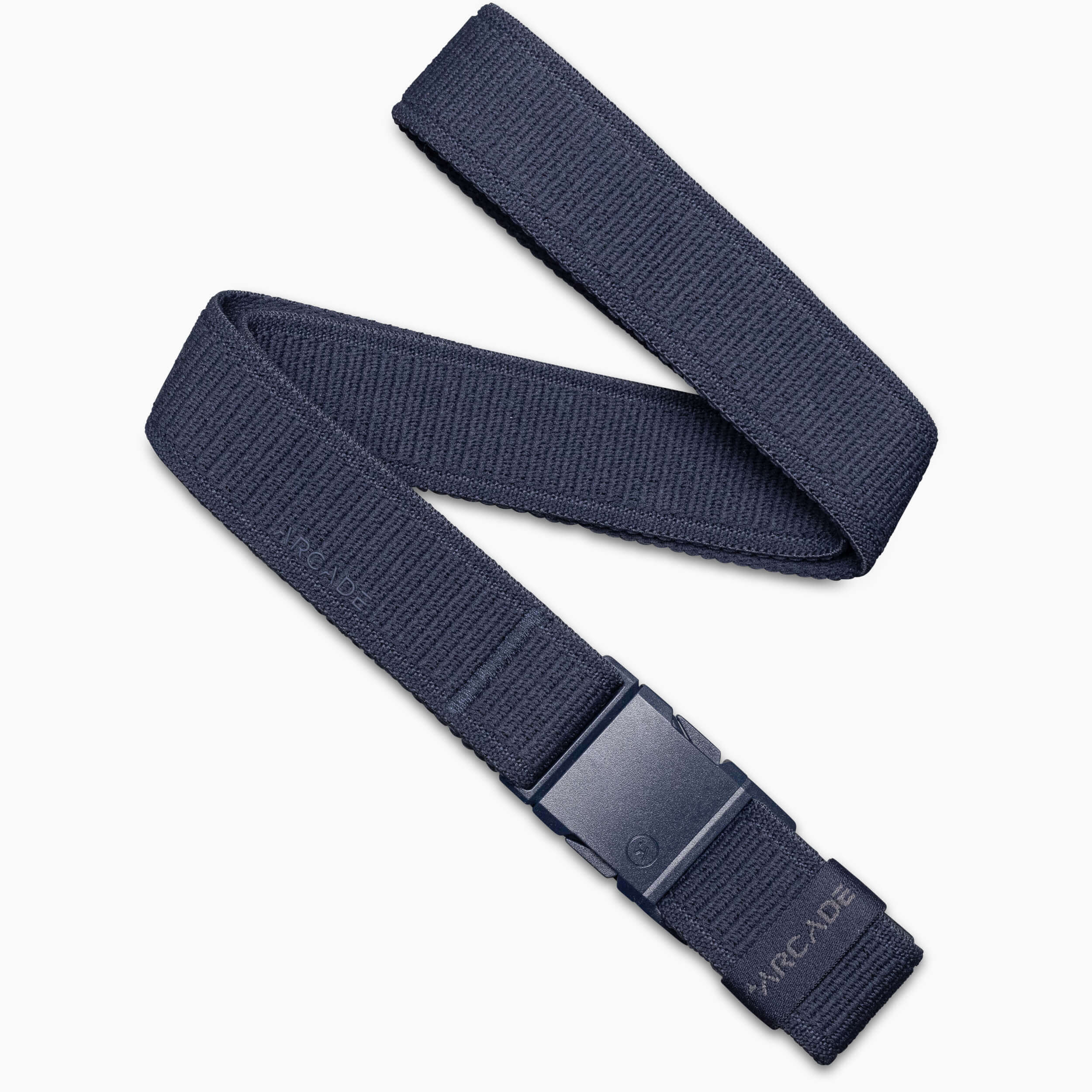 The Atlas belt by Arcade Belts is navy blue with a black plastic buckle featuring ARCADE embossed near it. This low-profile, elastic stretch belt ensures comfort and is displayed on a white background.
