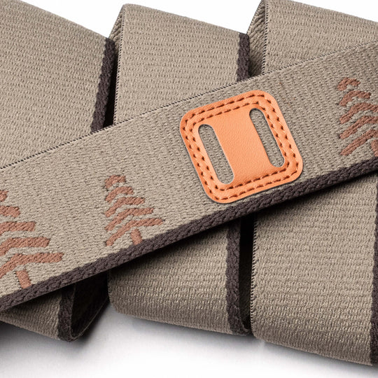 A close-up of the Arcade Belts Blackwood: a beige fabric strap with brown stitching, an A2 buckle, and a rectangular tan leather accent, neatly folded on a white background—ready for new adventures.