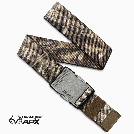 A camouflage-patterned Arcade Belts Hardware belt with a gray buckle, shown on a white background and designed for superior strength and durability. The Realtree APX logo is visible in the lower left corner.