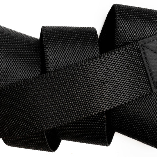 A close-up of the black Motion strap by Arcade Belts, featuring a woven texture and overlapping loops, set against a white background.