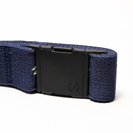 A close-up of the Arcade Belts Save the Waves navy blue elastic stretch belt featuring a black rectangular buckle, shown against a plain white background.