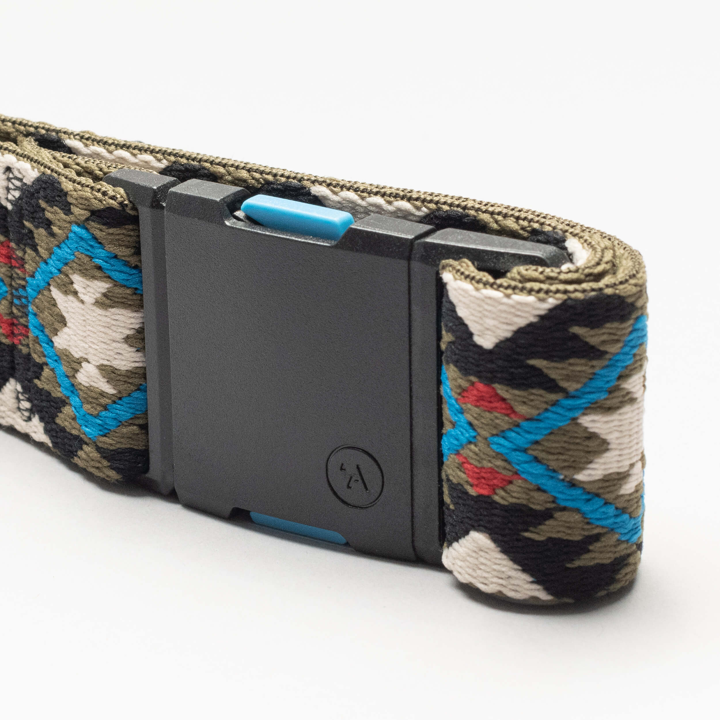 A close-up of the Arcade Belts Vernan Kee woven belt, showcasing a geometric blue, red, green, black, and white pattern with a matte black rectangular buckle and small circular logo—ideal for travel or anyone who loves stretch webbing.