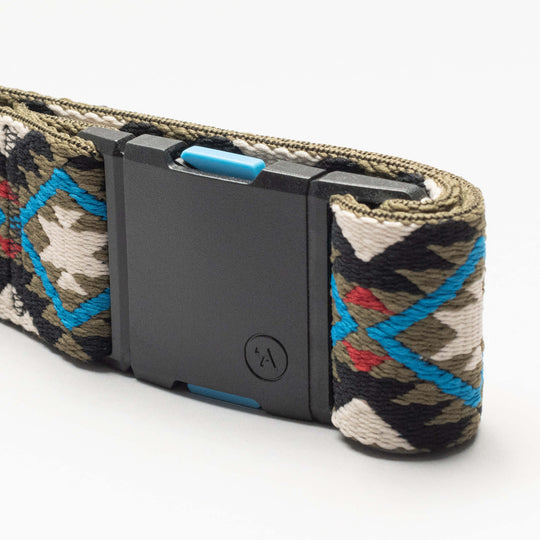 A close-up of the Arcade Belts Vernan Kee woven belt, showcasing a geometric blue, red, green, black, and white pattern with a matte black rectangular buckle and small circular logo—ideal for travel or anyone who loves stretch webbing.